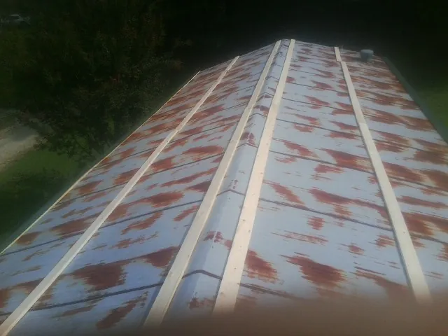 Rusted metal roof panels with new wood purlins before replacement — Storm Damage Roof Repair in Colgate by Roofing Brothers