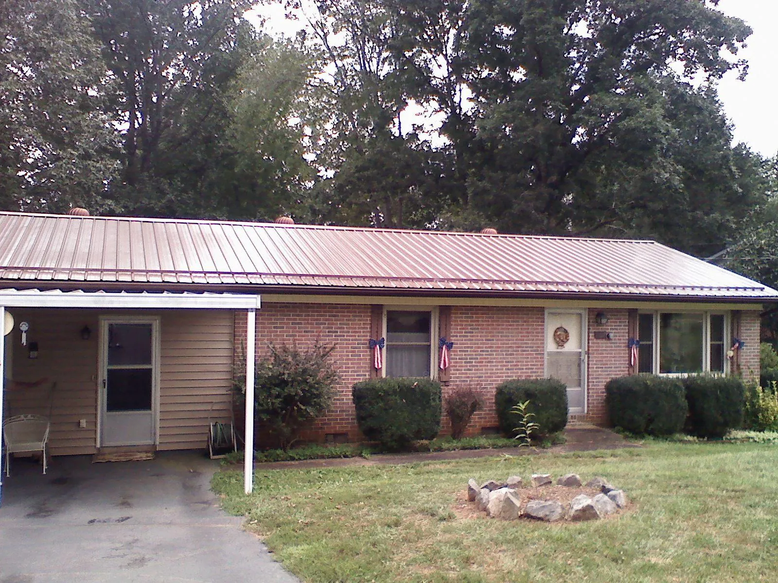 Bronze metal roof and carport on a brick ranch home — Roof Repair work by our crew in Colgate